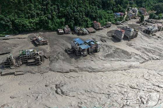 네팔 트리슐리에서 갑작스러운 홍수가 발생해 강변의 집들이 일부 물에 잠겨 있다./AFP=뉴스1