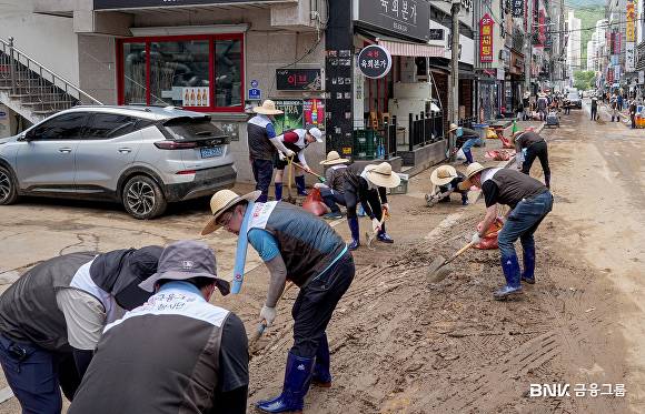 지난 19일 BNK금융그룹 임직원들이 경남 거제시 수해 현장을 찾아 복구 작업에 힘을 보태고 있다. [사진=BNK금융그룹]