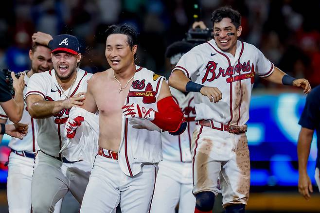 Atlanta Braves pinch-hitter Ha-Seong Kim, center, is mobbed by teammates Victor Mederos, left, and Mauricio Dubon, right, after Kim hit a game-winning RBI single against the Los Angeles Dodgers during the ninth inning of a baseball game, Wednesday, Aug. 26, 2026, in Atlanta. (AP Photo/Erik S. Lesser)        <저작권자(c) 연합뉴스, 무단 전재-재배포, AI 학습 및 활용 금지>