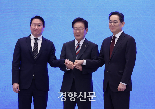 이재명 대통령과 이재용 삼성전자 회장, 최태원 에스케이(SK)그룹 회장이 29일 청와대에서 열린 ‘대한민국 대도약 3대 메가프로젝트 국민보고회’에서 손을 맞잡고 있다. 2026.06.29. 청와대사진기자단