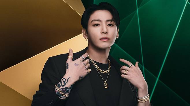 Jungkook usava brincos de pressão e argolas juntos, além de várias pulseiras e braceletes no pulso. Nos dedos, ele usava diversos anéis, incluindo o anel exclusivo da Laurence Graff e a aliança de casamento com diamantes facetados, também exclusiva da Laurence Graff. Foto: Graff