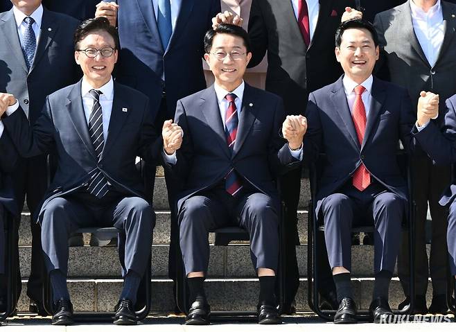 더불어민주당 김민석 대표와 조정식 국회의장, 장동혁 국민의힘 대표가 3일 서울 영등포구 국회의사당 본청 앞 계단에서 단체사진을 촬영하기 위해 손을 맞잡고 있다.