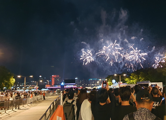 서울 여의도 한강공원에서 '서울세계불꽃축제 2026' 카운트다운 직후 첫 불꽃이 밤하늘로 솟아오르자 관람객들이 휴대전화를 들어 촬영하고 있다. 사진=최승한 기자