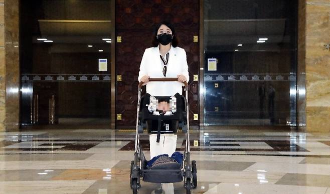 용혜인 기본소득당 의원이 2021년 7월5일 아들을 태운 유모차를 밀며 국회 본회의장 앞을 지나고 있다. 국민일보DB