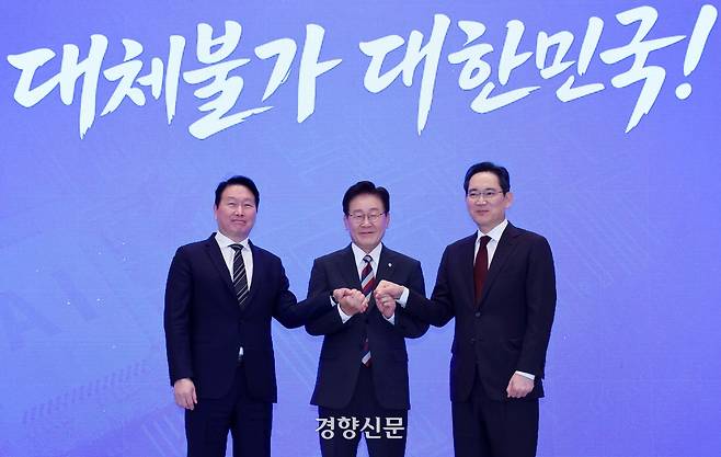 이재명 대통령이 6월 29일 청와대에서 열린 ‘대한민국 대도약 3대 메가프로젝트 국민보고회’에서 최태원 에스케이(SK)그룹 회장과 이재용 삼성전자 회장과 함께 손을 맞잡고 있다. 2026.06.29 청와대사진기자단