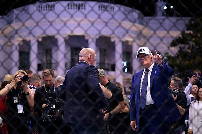 지난 6월 백악관에서 열린 UFC 대회에서 케이지에 올라 손짓하고 있는 도널드 트럼프 미국 대통령(오른쪽).  [게티이미지]