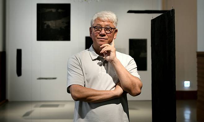 숯과 비즈를 활용한 ‘설치미술의 대가’ 박선기 작가가 개인전 ‘The Origin of Space’가 열리고 있는 신세계백화점 본점 더 헤리티지 뮤지엄에서 ‘집합체’ 연작 새 작품을 배경으로 포즈를 취하고 있다. 최현태 선임기자