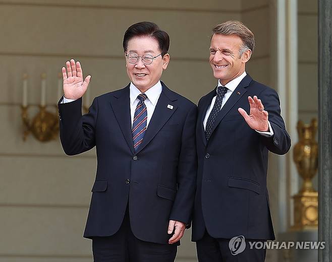 엘리제궁에서 만난 한-프랑스 정상 (파리=연합뉴스) 김도훈 기자 = 프랑스를 국빈방문 중인 이재명 대통령이 8일(현지시간) 파리 엘리제궁에서 영접 나온 에마뉘엘 마크롱 대통령과 취재진을 향해 손을 흔들고 있다. 2026.9.8 superdoo82@yna.co.kr