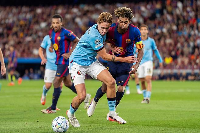 지난 10일 스페인 바르셀로나 스포티파이 캄노우에서 열린 페예노르트와의 유럽축구연맹(UEFA) 챔피언스리그 경기에서 FC바르셀로나의 라민 야말(오른쪽)이 토비아스 판 덴 엘스하우트와 공을 다투고 있다. 야말은 이날 골을 넣고 후반 주장 완장까지 넘겨받아 19세 58일로 바르셀로나 역대 최연소 주장 기록을 세웠다. 바르셀로나가 5-1로 이겼다. 신화연합뉴스