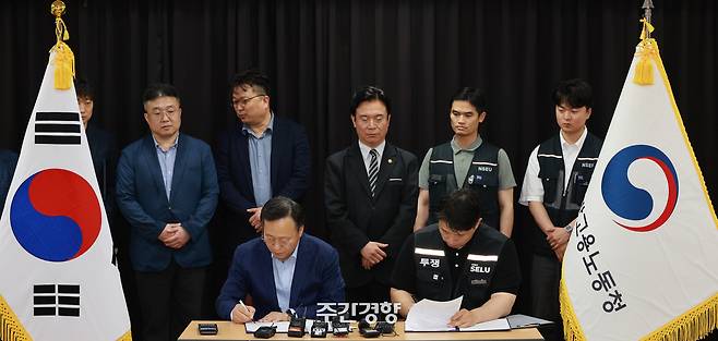 지난 5월 20일 경기도 수원시 장안구 경기고용노동청에서 열린 삼성전자 임금협상을 마친 후 여명구 삼성전자 DS(디바이스솔루션·반도체 사업 담당) 피플팀장과 최승호 삼성그룹 초기업노동조합 삼성전자지부 위원장이 잠정 합의안에 서명하고 있다. 언론사 공동취재