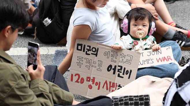 8개월 이지구 아기가 12일 오후 서울 종로구 르메이에르빌딩 앞에서 열린 호르무즈 해협 파병 반대 집회에 부모님과 함께 참석하고 있다. 김영원 기자 forever@hani.co.kr