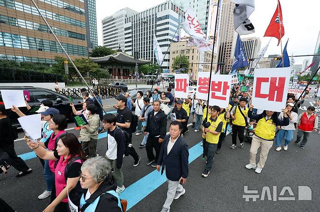 [서울=뉴시스] 황준선 기자 = 12일 서울 종로구 세종대로 사거리 인근에서 열린 '미국은 침략전쟁 중단하라! 정부는 호르무즈 파병 단호히 거부하라! 시민 대행진'에서 참석자들이 청와대를 향해 행진하고 있다. 2026.09.12. hwang@newsis.com