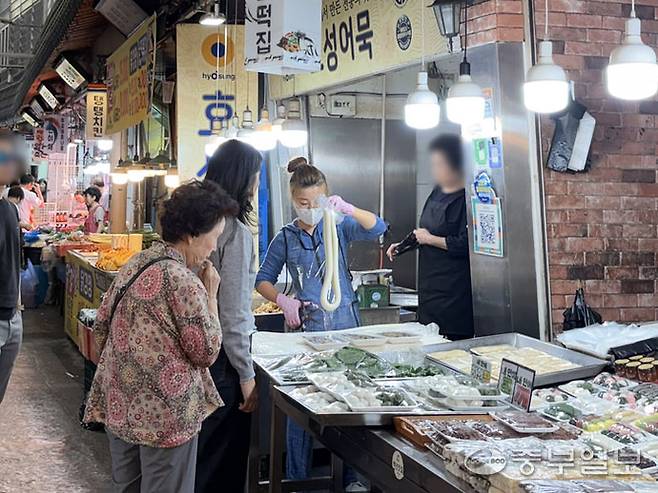16일 수원시 팔달구 못골시장의 한 떡집에서 손님이 떡을 구매하고 있다. 왕보빈기자