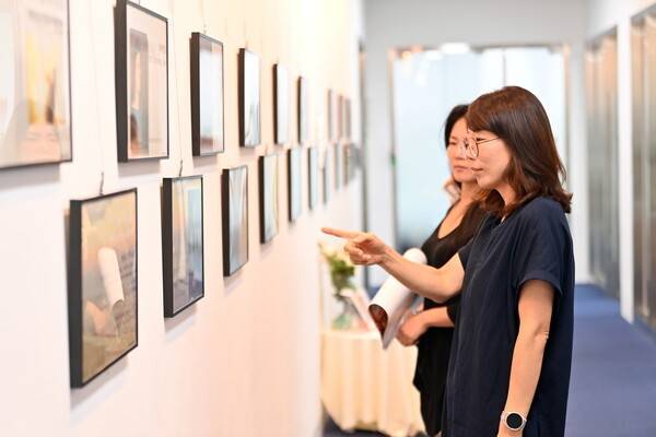 위례도서관 아트월에 마련된 기획전시 '우물 속의 얼굴들-자화상으로 만나는 예술가와 나'를 찾은 시민들이 전시된 작품을 관람하고 있다.