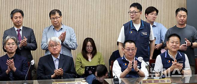 서울 시내버스 노사 협상이 극적으로 타결돼 16일 오전 서울 영등포구 서울지방노동위원회에서 김정환 서울시버스사업조합 이사장(앞줄 왼쪽두번째)과 박점곤 서울시버스노동조합 위원장이 조정안에 서명 후 박수를 치고 있다./사진=뉴시스