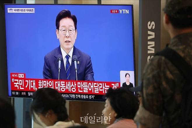 18일 오전 서울 용산구 서울역에서 시민들이 이재명 대통령의 대국민 기자회견 생중계를 시청하고 있다. ⓒ데일리안 홍금표 기자