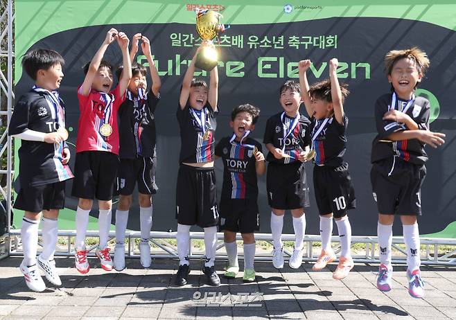 제1회 일간스포츠배 유소년 축구대회가 20일 경기 하남종합운동장 보조 A구장에서 열렸다.2학년 리그에서 우승을 차지한 토리 FC가 트로피를 들고 포즈를 취하고 있다.일간스포츠와 에버킥이 주최한 이번 대회는 유치부부터 초등학교 6학년까지 축구 꿈나무들이 참가해 기량을 펼치며, 미래 스포츠 인재를 발굴하고 가족이 함께 즐기는 스포츠 문화를 확산하기 위해 마련됐다.하남=서병수 기자 qudtn@edaily.co.kr /2026.09.20/