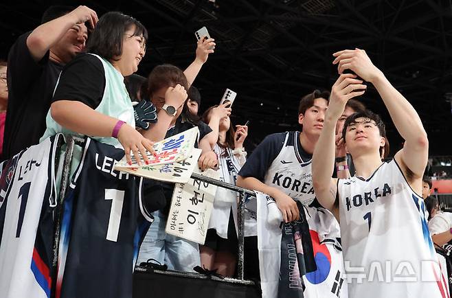 [나고야=뉴시스] 김금보 기자 = 18일 오후(현시시간) 일본 아이치현 나고야시 아이치 인터내셔널 아레나에서 열린 2026 아이치·나고야 아시안게임 남자 농구 준결승 한국과 이란의 경기, 77대51로 승리한 한국 이현중이 관중들과 기념촬영을 하고 있다. 2026.09.18. kgb@newsis.com