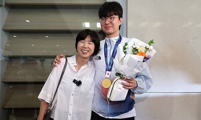 농구 이현중 금의환향… 베이징대회 金 출신 어머니와 활짝 2026 아이치·나고야 아시안게임에서 한국 남자 농구가 12년 만에 금메달을 따는 데 앞장선 이현중(오른쪽)이 21일 인천국제공항으로 귀국해 마중 나온 어머니 성정아 대한농구협회 이사와 환한 웃음을 터뜨리고 있다. 1990 베이징 아시안게임 금메달을 딴 성 이사와 이현중은 ‘모자(母子) 메달리스트’가 됐다. 인천공항=뉴스1