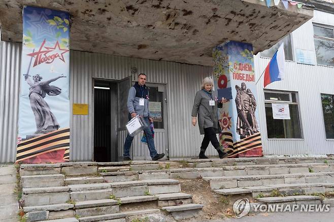 20일(현지시간) 모스크바 남부 칼루가 지역의 투표소 나서는 선관위 사무원들 [AFP 연합뉴스. 재판매 및 DB 금지]