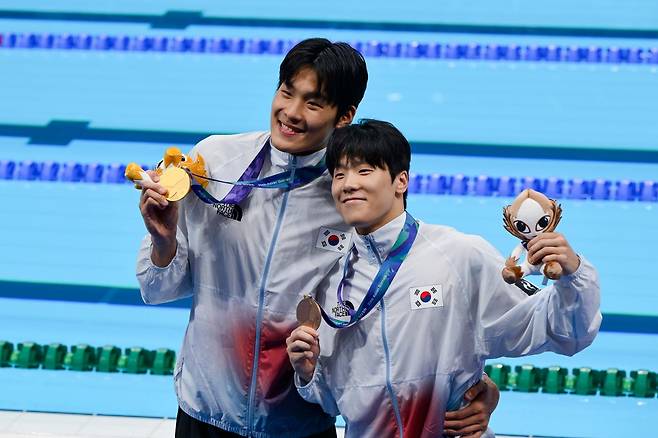 남자 자유형 50m 금메달 김영범(왼쪽)과 동메달 지유찬이 21일 일본 도쿄 아쿠아틱스센터에서 열린 2026 아이치·나고야 아시안게임 수영 시상식을 마친 뒤 관중석 앞에서 메달을 목에 걸고 기념촬영을 하고 있다. 도쿄=하상윤 기자