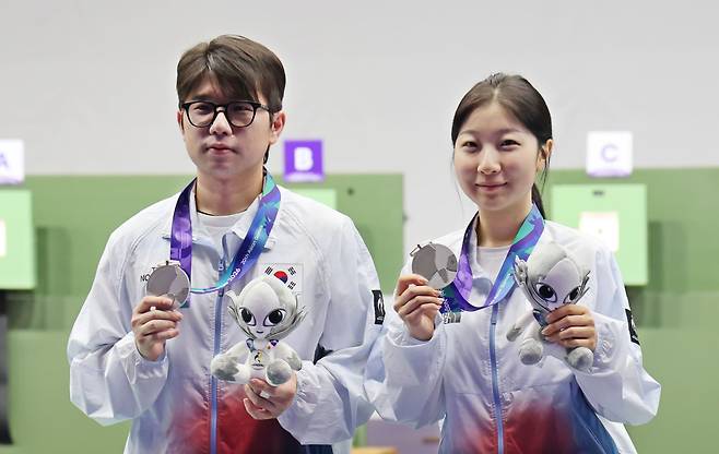 22일 일본 아이치현 종합 사격장에서 열린 2026 아이치·나고야 아시안게임 사격 10m 공기소총 혼성 단체전 시상식에서 은메달을 차지한 한국 반효진(오른쪽)과 박하준이 메달을 들고 포즈를 취하고 있다. 연합뉴스