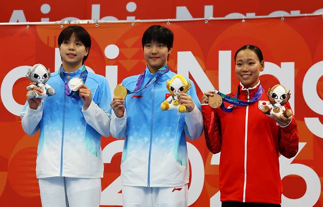 Asian Games - Aichi-Nagoya 2026 - Swimming - Tokyo Aquatics Centre, Koto, Tokyo, Japan - September 20, 2026 Gold medallist China's Yu Zidi celebrates after winning the women's 200m butterfly final along with silver medallist China's Chang Mohan and bronze medallist Japan's Misa Okuzono REUTERS/Manami Yamada

<저작권자(c) 연합뉴스, 무단 전재-재배포, AI 학습 및 활용 금지>