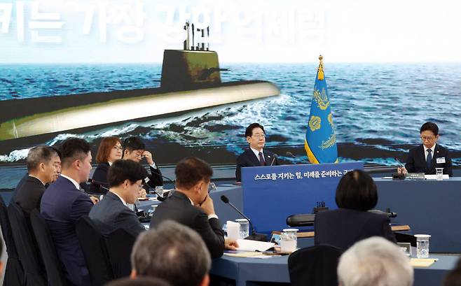 이재명 대통령이 지난 5월 26일 경남 창원시 진해구에서 열린 제1회 미래국방전략위원회에서 안규백 국방부 장관의 핵추진잠수함 개발 기본계획 보고를 듣고 있다. [연합뉴스 제공]
