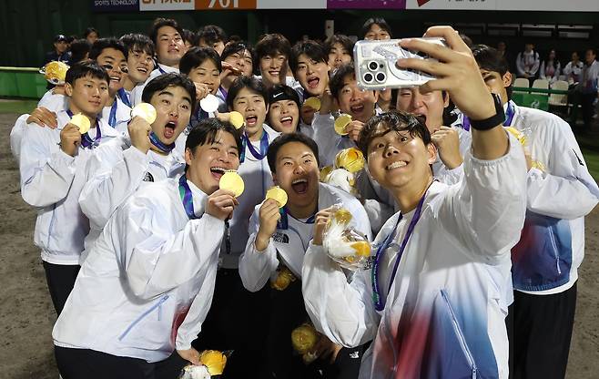 27일 일본 아이치현 도요하시 시민구장에서 열린 2026 아이치·나고야 아시안게임 야구 결승에서 금메달을 차지한 대한민국 대표선수들이 메달을 목에 걸고 셀카를 찍고 있다. 연합뉴스