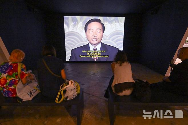 [전남광주=뉴시스] 이영주 기자 = 4일 오후 전남광주 북구 운암동 광주비엔날레 전시관에서 관람객들이 제임스.T.홍 작가의 작품 '사과'를 감상하고 있다. 작품은 전 세계 정치인들의 사과영상을 모아 반성과 책임의 언어로 표현하고 있다.  제16회 광주비엔날레는 "너는 네 삶을 바꿔야 한다"를 주제로 오는 5일부터 11월15일까지 72일간 열린다. 2026.09.04. leeyj2578@newsis.com
