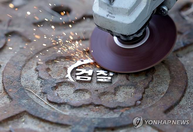 지워지는 검찰 마크 (서울=연합뉴스) 류영석 기자 = 공소청 출범을 사흘 앞둔 29일 서울 서초구 대검찰청에서 작업자들이 맨홀 뚜껑에 새겨진 검찰 마크를 지우고 있다. 2026.9.29 ondol@yna.co.kr