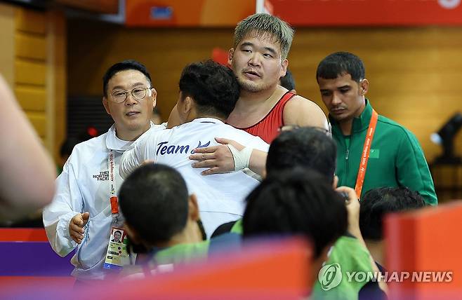 AG 3회 연속 메달 획득한 김민석 (나고야=연합뉴스) 이동해 기자 = 30일 일본 나고야 이나에 스포츠센터에서 열린 2026 아이치·나고야 아시안게임 레슬링 남자 그로코로만형 130kg급 동메달 결정전에서 한국 김민석이 투르크메니스탄의 아슬란 아가다다예프를 상대로 승리한 뒤 감독·코치와 포옹하고 있다.
    이날 김민석은 아슬란 아가다다예프를 7-2로 꺾고 아시안게임 3회 연속 메달 획득이라는 값진 성과를 거뒀다. 2026.9.30 eastsea@yna.co.kr