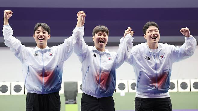 1일 일본 아이치현 종합사격장에서 열린 2026 아이치·나고야 아시안게임 사격 남자 25ｍ 속사권총 단체전에서 금메달을 차지한 한국 송종호(왼쪽부터), 이건혁, 윤서영이 시상대에 올라 기뻐하고 있다. /연합뉴스
