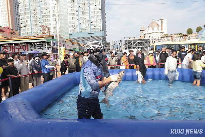 지난해 열린 시흥월곶포구축제에서 한 참가자가 맨손고기잡이 체험을 하고 있다. 시흥시 제공.