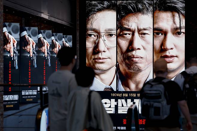 고(故) 육영수 여사 피격 사건을 다룬 허진호 감독의 영화 <암살자(들)>을 둘러싼 정치권 논란이 계속되는 가운데 지난달 28일 한 시민이 서울의 한 극장에 걸린 영화 포스터 앞을 지나고 있다.  문재원 기자