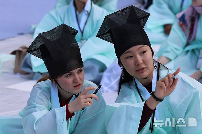 [서울=뉴시스] 권창회 기자 = 5일 서울 종로구 성균관대학교에서 열린 '제1회 재한 외국인 과거 시험'에서 참가자들이 과거시험 문제를 보고 대화하고 있다. 2026.10.05. kch0523@newsis.com