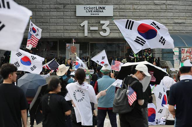 6·3 지방선거 투표용지 부족 사태로 인한 '개표소 봉쇄 시위'가 계속되고 있는 18일 서울 송파구 올림픽공원 핸드볼경기장 출입문 앞에서 참가자들이 구호를 외치고 있다. 연합뉴스