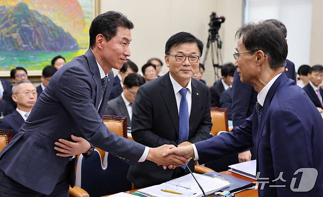 장민영 IBK기업은행장과 박상진 한국산업은행 회장이 8일 서울 여의도 국회에서 열린 정무위원회 국정감사에 출석해 유동수 정무위원장과 인사를 나누고 있다. 2026.10.8 ⓒ 뉴스1 김도우 기자