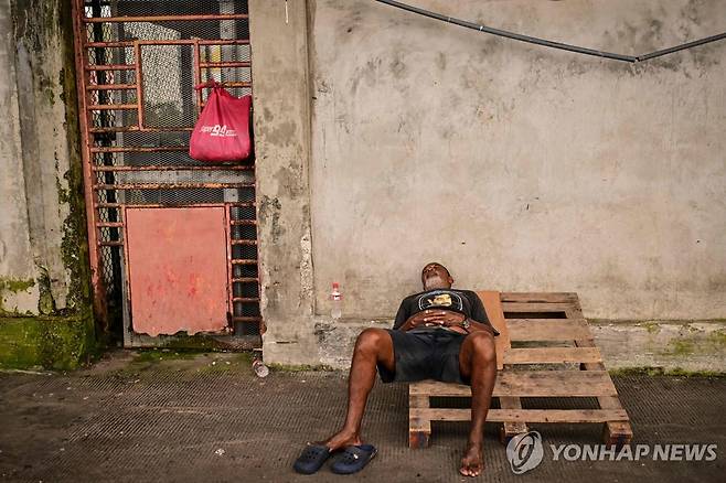 부두에서 휴식 취하고 있는 어부 [AFP=연합뉴스. 재판매 및 DB 금지]