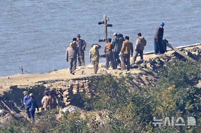 [김포=뉴시스] 김금보 기자 = 7일 오후 경기 김포시 애기봉전망대에서 바라본 북한 개풍군 접경지에서 북한 주민들이 철책 및 전술도로 공사 석재를 옮기고 있다. 2026.10.07. kgb@newis.com