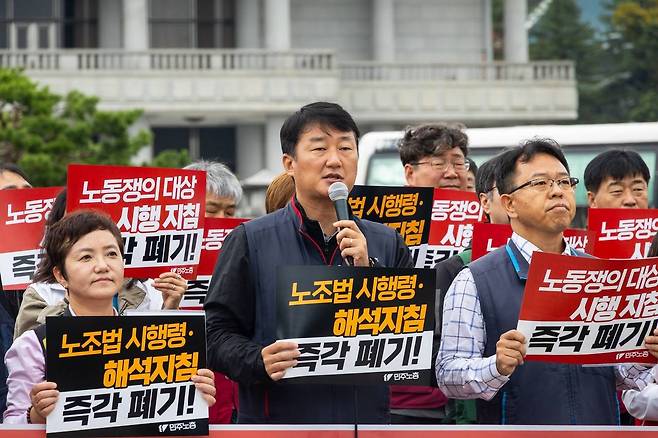 양경수 민주노총 위원장(가운데)이 13일 서울 종로구 청와대 사랑채 앞에서 기자회견을 열고 원청교섭 실현과 노동조합법 시행령·해석지침, 노동쟁의 대상 시행지침 폐기를 촉구하고 있다. [민주노총 제공]
