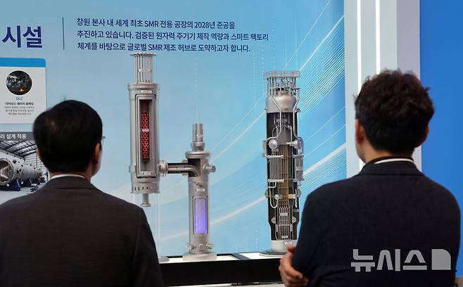 [부산=뉴시스] 하경민 기자 = '2026 기후산업국제박람회'가 열린 16일 부산 해운대구 벡스코 제1전시장 두산에너빌리티 부스에서 관람객들이 SMR(소형모듈식원자로) 모형을 둘러보고 있다.  2026.09.16. yulnetphoto@newsis.com