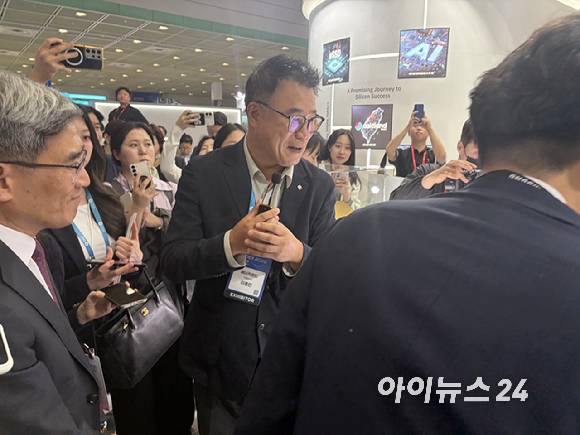 14일 서울 강남구 코엑스에서 열린 '반도체대전(SEDEX 2026)'에서 이종민 에이직랜드 대표가 송재혁 삼성전자 CTO 사장 등 주요 인사들에게 자사 기술을 소개하며 웃고 있다. [사진=권서아 기자]