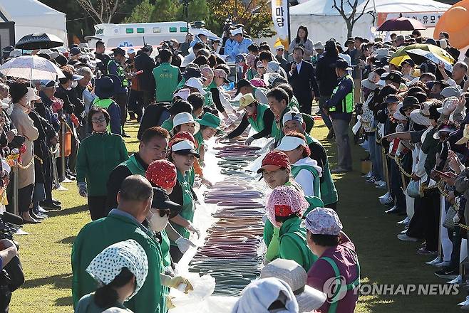 600m 무지개 가래떡 만들기 (이천=연합뉴스) 홍기원 기자 = 14일 경기도 이천시 복하천 수변공원에서 열린 '제25회 이천쌀문화축제'에서 참석자들이 600m 무지개 가래떡을 만들고 있다. 2026.10.14 xanadu@yna.co.kr