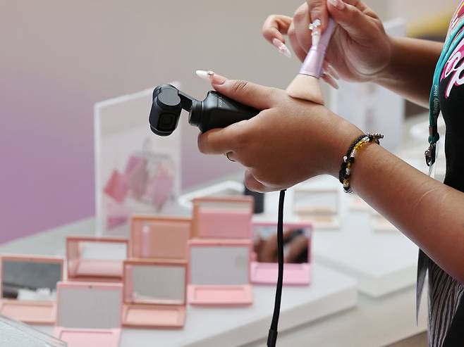 A visitor tests a cosmetics product during the 2025 Seoul Beauty Week at the Dongdaemun Design Plaza in Jung District, central Seoul, on Aug. 28, 2025. YONHAP