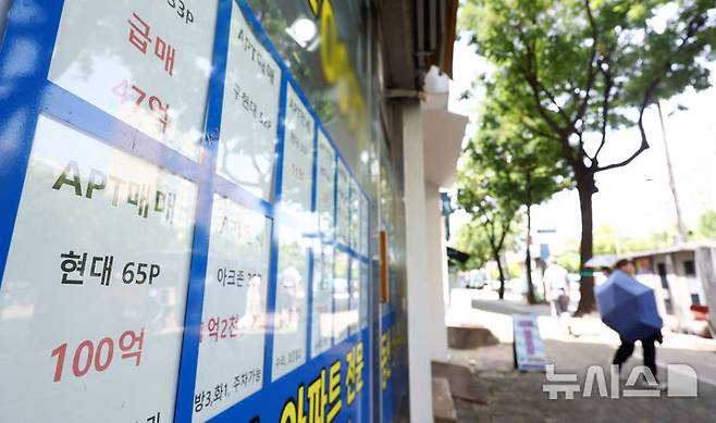 [서울=뉴시스] 전신 기자 = 정부의 세제 개편안 발표 이후 서울 아파트 매물이 2000건 넘게 늘어난 것으로 나타난 가운데 10일 서울 강남구 한 부동산 중개업소 앞을 시민들이 지나고 있다.증가분의 절반이상이 강남3구에 집중되면서, 고가·초고가 주택의 보유세 부담 확대에 민감한 지역부터 매도 움직임이 나타난 것으로 풀이된다. 2026.08.10. photo1006@newsis.com