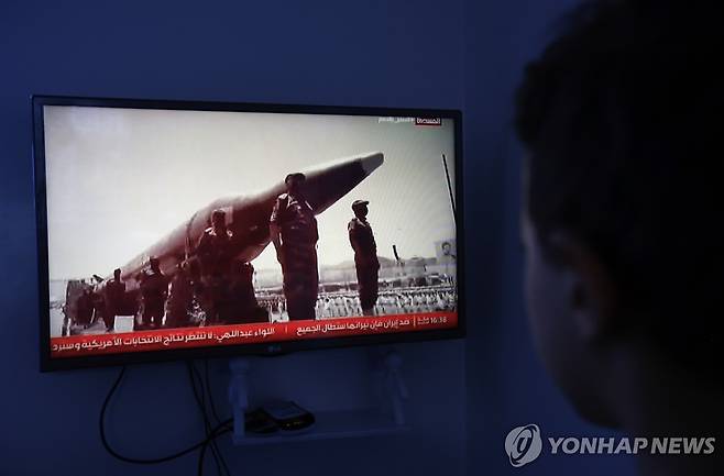 예멘 사나에서 예멘 교전 관련 최신 동향을 전하는 TV 방송을 한 남성이 지켜보고 있다. 화면에는 미사일 주위에 도열한 후티 반군 대원들의 모습이 담겨 있다. [EPA=연합뉴스 자료사진. 재판매 및 DB 금지]