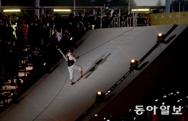 한민수가 2018 평창 겨울패럴림픽 개회식에서 의족을 한 채 성화를 등에 매달고 로프에 의존해 암벽을 타듯 성화대로 향하고 있다. 평창=홍진환 기자 jean@donga.com