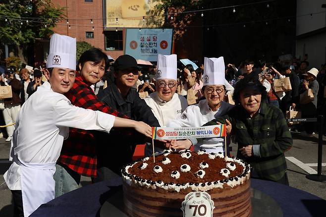 대전지역 제과점 성심당이 창업 70주년을 맞아 17일 오후 대전 중구 성심당문화원에서 방문객들과 함께 ‘성심당 칠순잔치 케익나눔’행사를 하고 있다. 연합뉴스