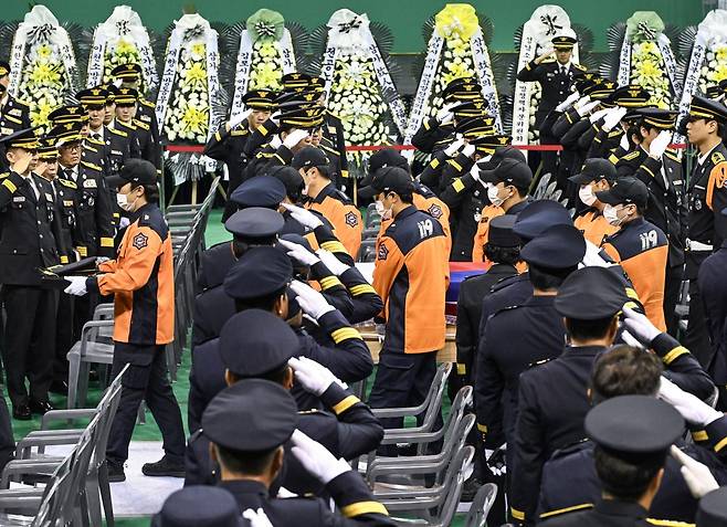 19일 경기도 부천시 원미구 부천실내체육관에서 열린 ‘고(故) 김진석 소방위 영결식’에서 소방대원들이 김 소방위의 운구행렬에 경례하고 있다. 사진공동취재단